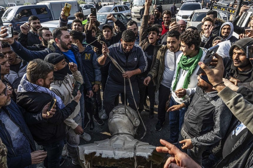 Citizens in Syria take down statues of Hafez al-Assad, the father of Bashar al-Assad, in Damascus on Monday. (Credit: Murat Sengul/Anadolu via Getty Images)