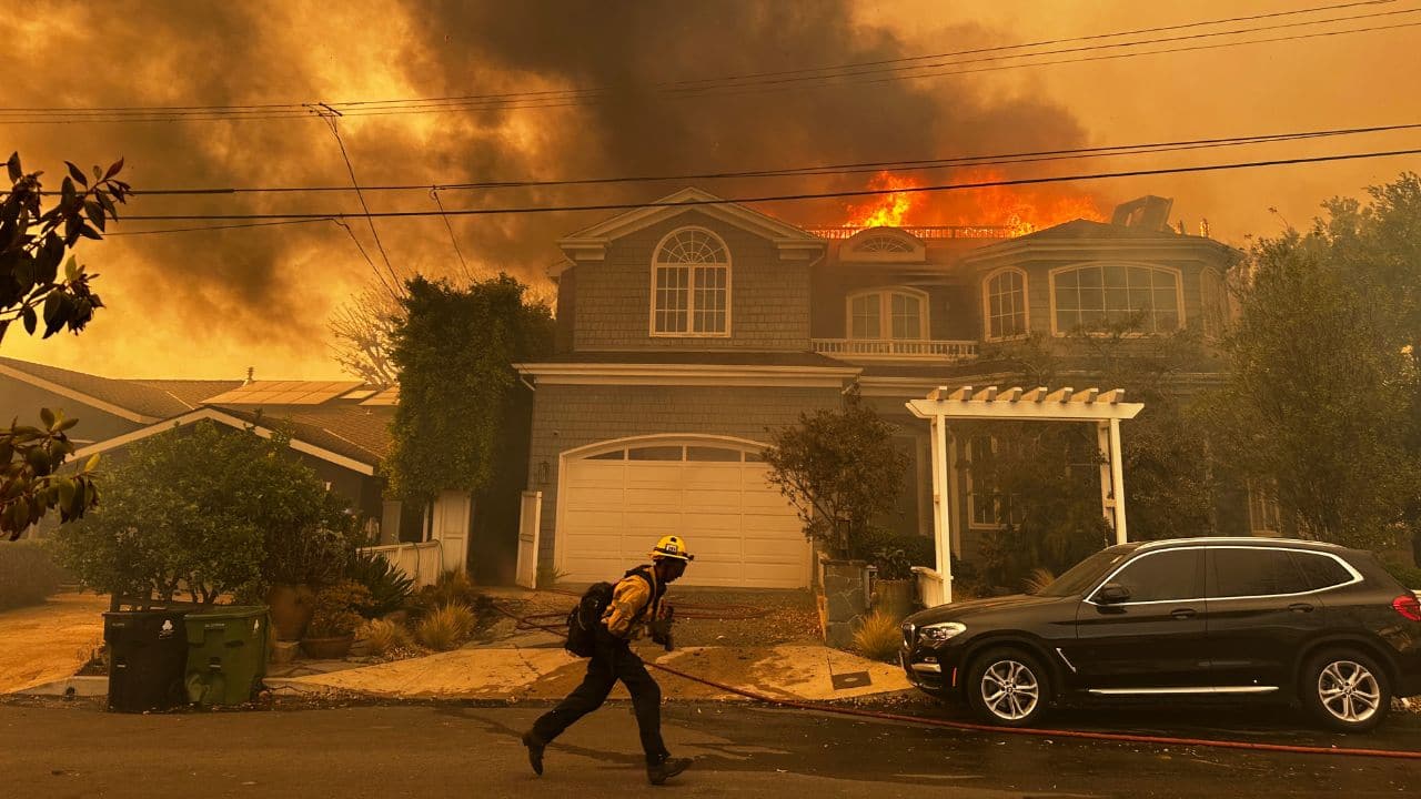 CALIFORNIA WILDFIRES 2025: A home burns as a firefighter combats the Palisades Fire in the Pacific Palisades area of Los Angeles on Tuesday, Jan. 7, 2025. (Image: AP)