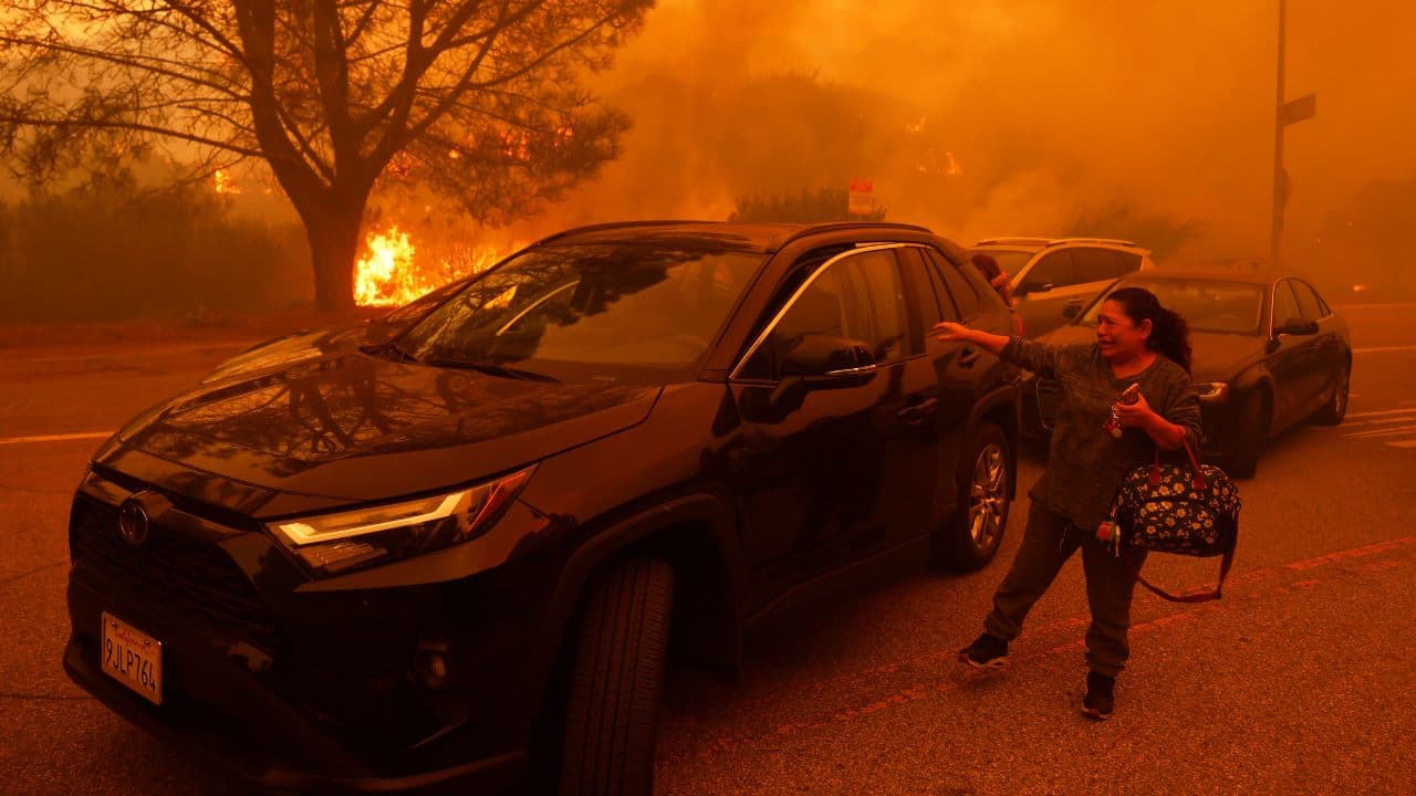 CALIFORNIA WILDFIRES 2025: A woman weeps as the Palisades Fire spreads through the Pacific Palisades neighborhood of Los Angeles on Tuesday, Jan. 7, 2025. (Image: AP)