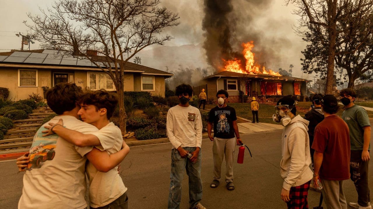 CALIFORNIA WILDFIRES 2025: Residents stand outside a burning property as the Eaton Fire ravaged Altadena on Wednesday, Jan. 8, 2025. (Image: AP)