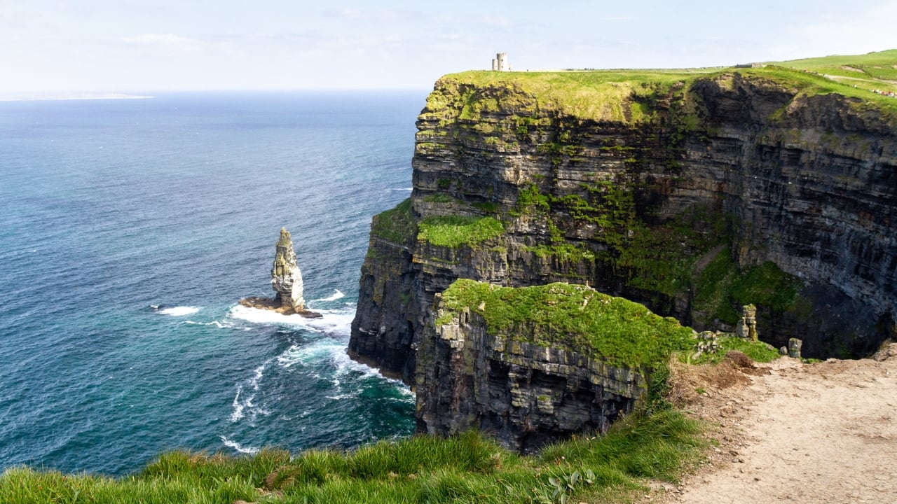 1. Cliffs of Moher, Ireland The Cliffs of Moher rise dramatically 700 feet above the Atlantic Ocean, offering a fairytale-like view. With mist, wild waves, and distant islands, it’s a must-visit destination for panoramic beauty. (Image: Canva)