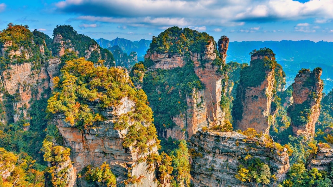 10. Zhangjiajie Cliffs, China The surreal sandstone pillars of Zhangjiajie inspired the floating mountains in Avatar. These dramatic cliffs rise from the forest, creating a fantasy-like landscape that’s a must-see for nature and adventure lovers. (Image: Canva)