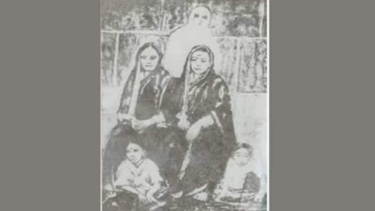 An old photo negative of both women sitting side by side with two female students near their feet published by the Maharashtra government.