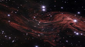 This shimmering cosmic curtain shows interstellar gas and dust that has been heated by the flashbulb explosion of a long-ago supernova.  (Image: NASA)