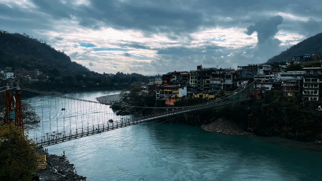 2. Rishikesh: Dubbed the Yoga Capital of the World, Rishikesh offers a mix of tranquility and adventure. Meditate by the Ganges at Parmarth Niketan, marvel at the iconic Laxman Jhula, and enjoy exhilarating activities like river rafting, bungee jumping, and trekking through lush trails. (Image: Canva)