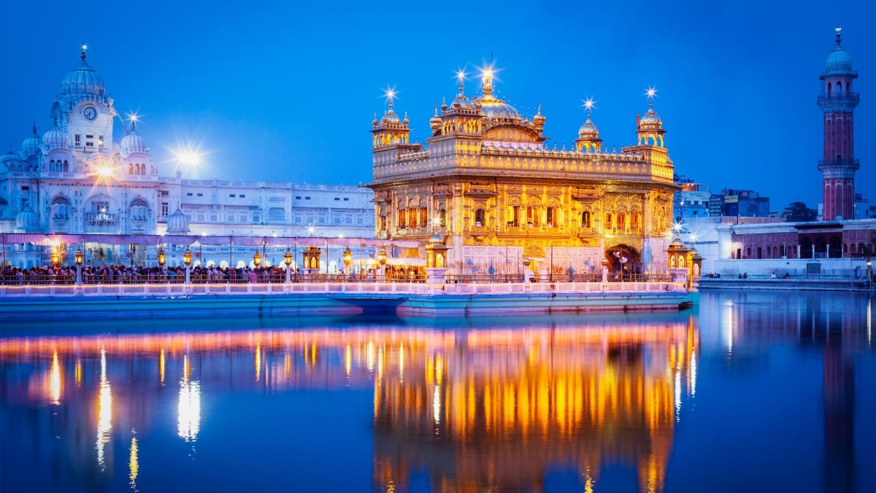7. Amritsar: This vibrant city is a perfect blend of spirituality and patriotism. Visit the Golden Temple, participate in the Langar, and attend the Wagah Border ceremony. Savor authentic Punjabi dishes like Amritsari kulcha and lassi for a complete experience. (Image: Canva)