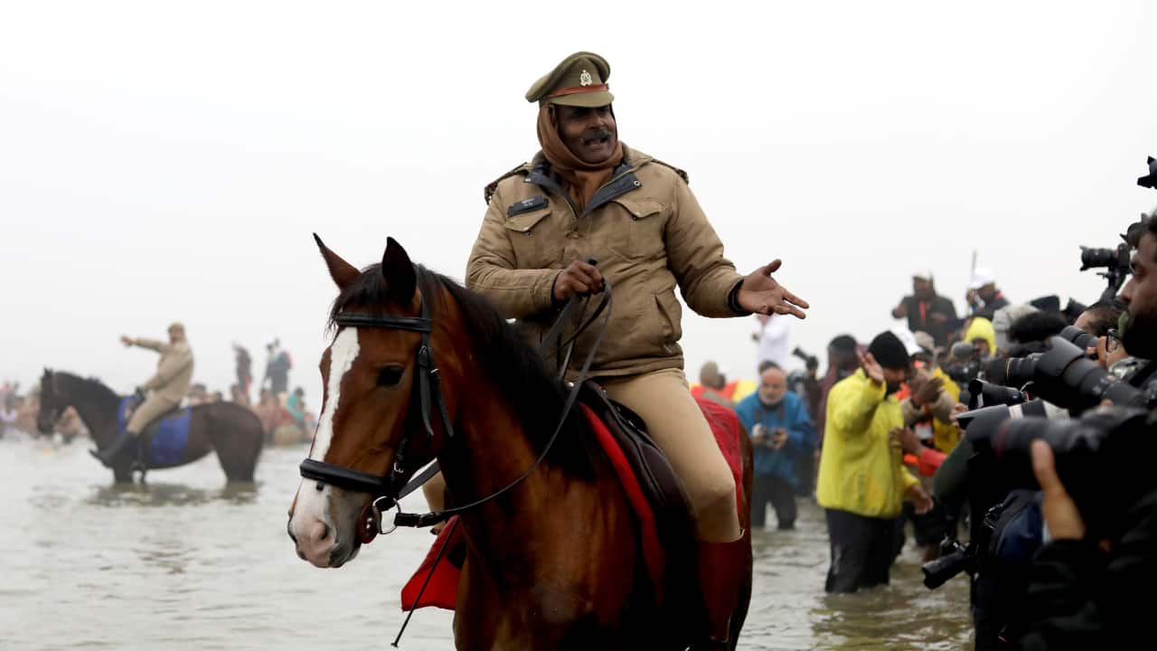Horseback in Water: The sight of police officers patrolling on horseback in shallow waters is a testament to their dedication. Their unique approach ensures safety in even the most challenging areas. (Image: Sanjit Kumar)
