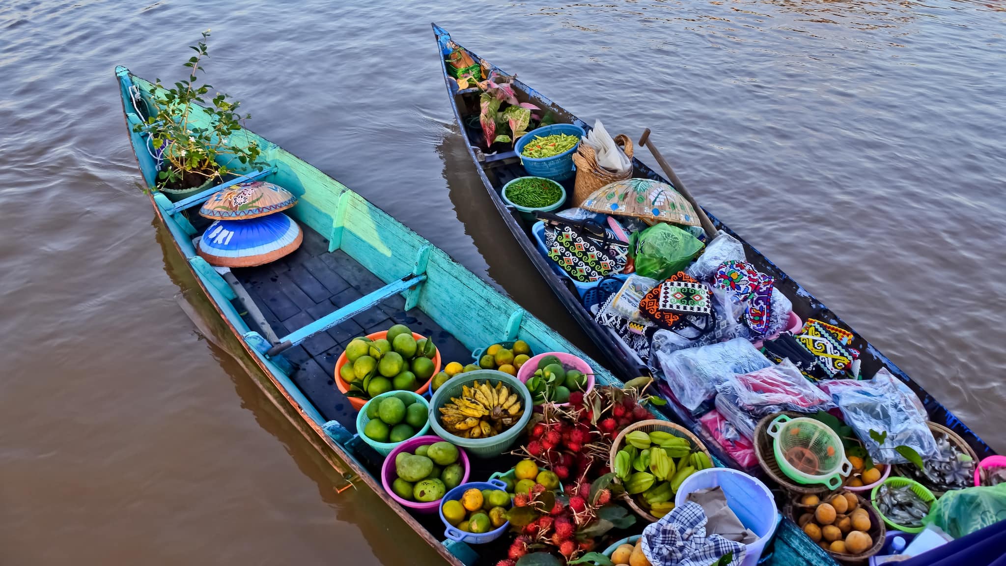 7. Lok Baintan Floating Market, Indonesia The Lok Baintan market in Banjarmasin, Indonesia, is a magical early morning experience. Floating along the river at sunrise, you’ll get a glimpse into the daily lives of local vendors who trade fruits, snacks, and regional specialties while navigating the waters in traditional wooden boats. Best Time to Visit: Sunrise – for the best photos and a peaceful market experience. (Image: Canva)