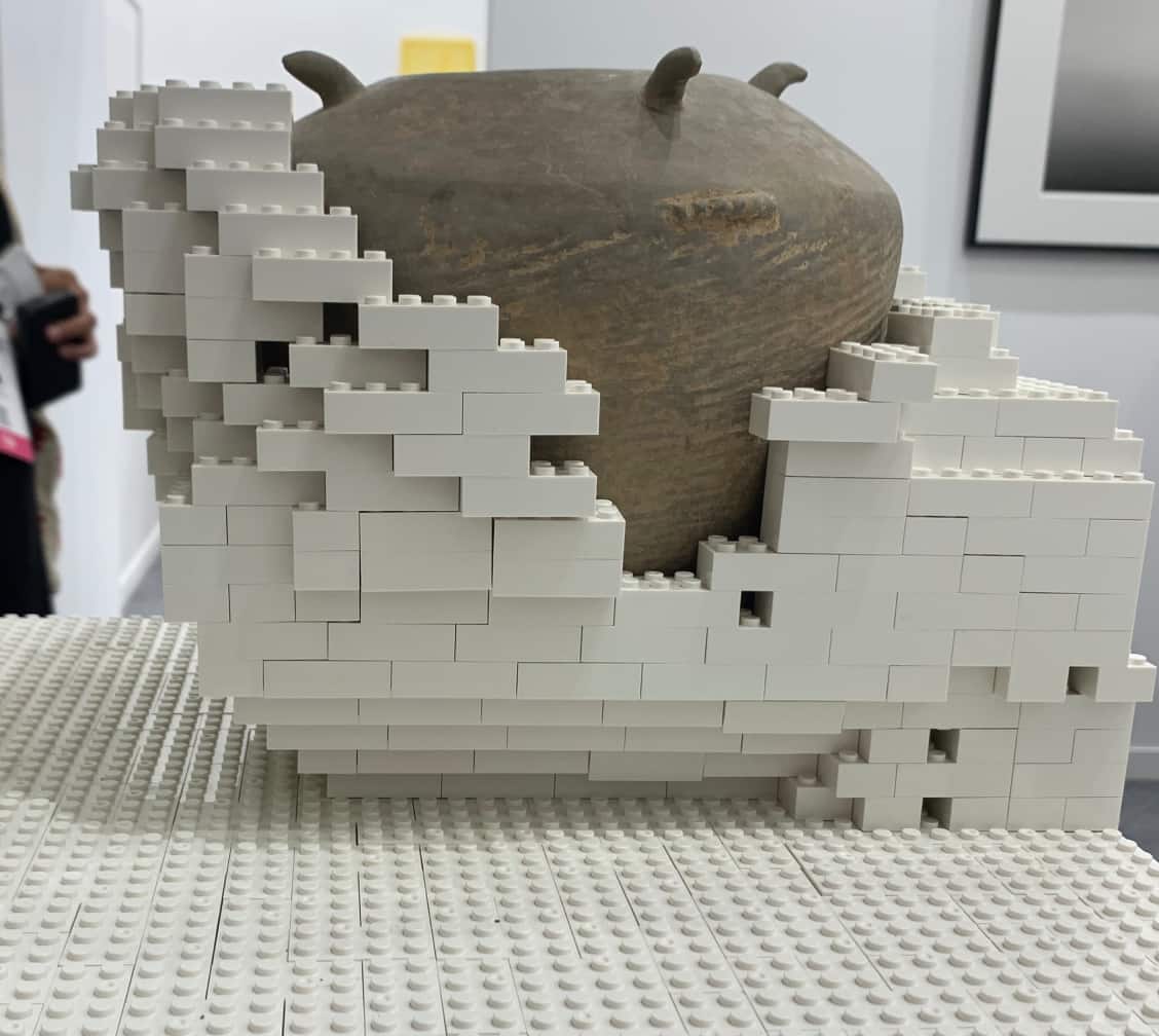 Works by Chinese artist Ai Weiwei are back at the India Art Fair in its 16th edition. In this 2023 piece, titled simply Neolithic Vase Merged with Toy Bricks, he's placed a GBP 5,000-plus historical vase on a pedestal of plastic Lego-like blocks. Is it a comment on how we package and repackage our histories and toy with tradition, hoping that the cheap scaffolding can serve as a worthy vestibule for world histories? Or perhaps the reverse, that this meaning-finding in historical objects that were once articles of daily use is pulling the wool over ordinary people's eyes, giving them an inflated sense of the nation's importance in world history? Ai has, in the past, smashed an historical vase and painted the Coca-Cola logo on another one to make his art. So, see, and read your meanings into the work. Or just marvel at the congruity of the piece that should have seemed incongruous, even on paper.
