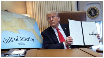 US President Donald Trump holding up a proclamation renaming the Gulf of Mexico to the Gulf of America, while flying over it en route to New Orleans to attend the Super Bowl. (Courtesy: Reuters photo)