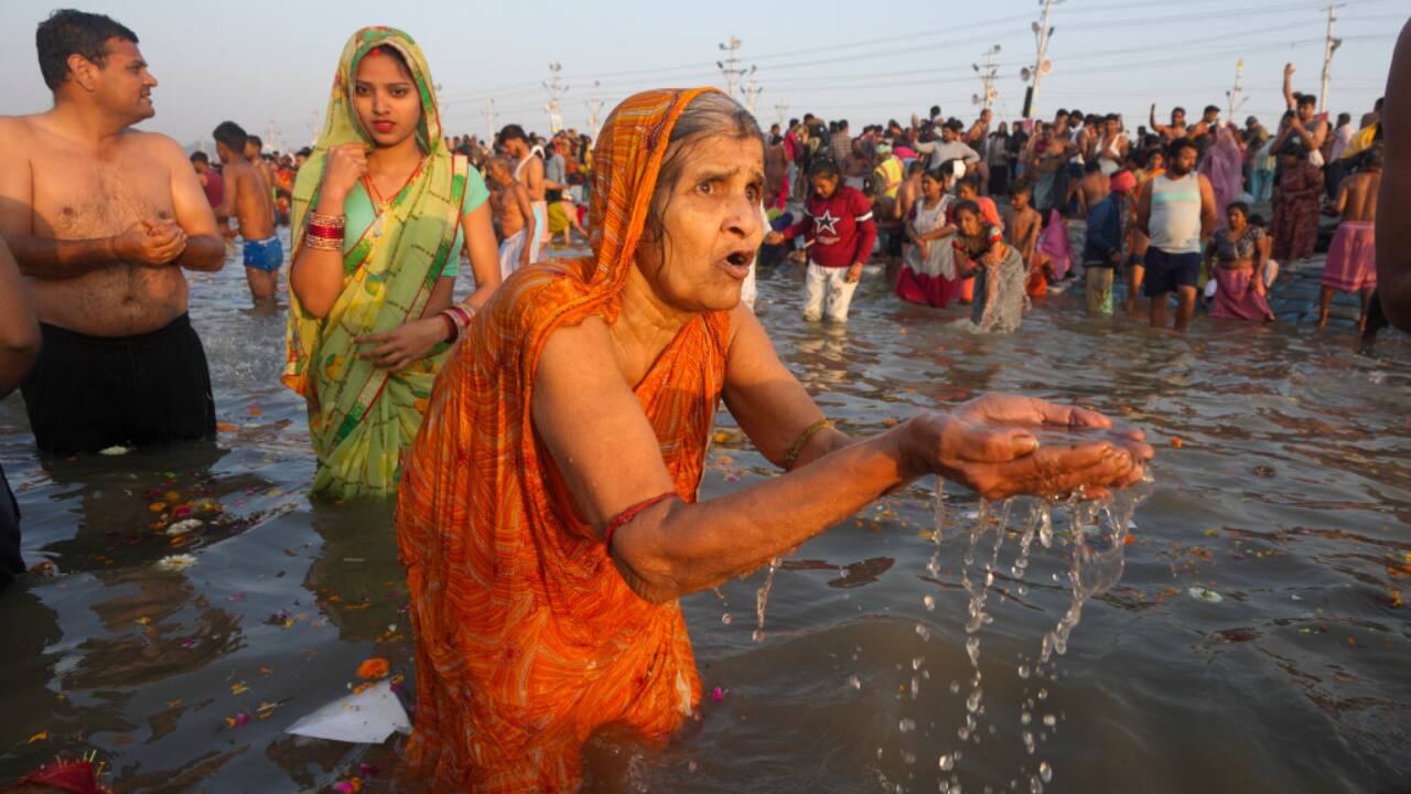 Women devotees in vibrant sarees take a dip, offering prayers to the Sun God while performing traditional rituals, embracing the sacred essence of Maghi Purnima at Maha Kumbh. (Image: PTI)