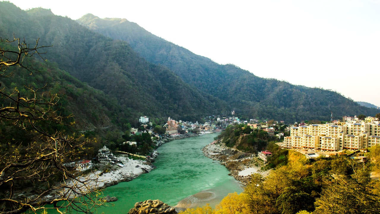2. Rishikesh – The Gateway to Spiritual Awakening | Nestled in the foothills of the Himalayas, Rishikesh is known as the &quot;Yoga Capital of the World.&quot; Situated on the banks of the sacred River Ganges, this town is a sanctuary for yogis and spiritual seekers worldwide. The atmosphere is filled with the sound of flowing water and chants from ashrams and temples, creating a serene and introspective ambiance. (Image: Canva)