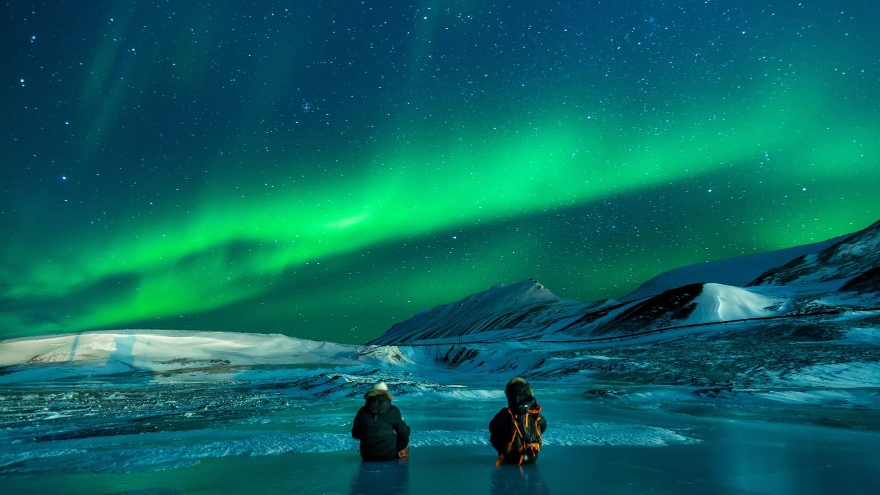 6. Chase the Northern Lights in Norway Instead of cuddling up for a movie night, why not watch nature’s most mesmerizing light show? Stay in a cozy glass igloo in Norway or Finland and watch the aurora borealis dance above you. Want to make it even more magical? Take a reindeer sled ride through the snow and chase the lights together. (Image: Canva)