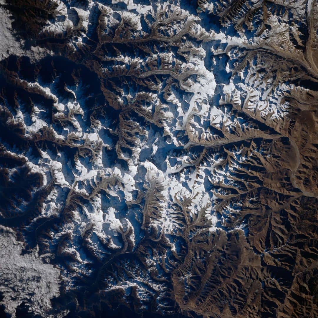 This view from space shuttle Columbia shows Mount Everest, which reaches 29,028 feet in elevation (8,848 meters), along with many glaciers. Mount Everest is to the left of the V-shaped valley. (Image: NASA)
