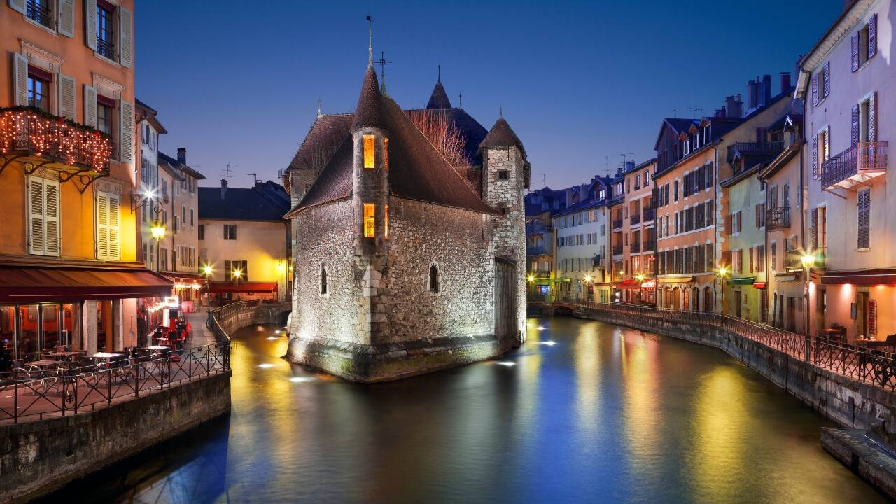 6. Annecy, France – The Alpine Venice You Didn’t Know You Needed Sitting on the shores of a crystal-clear lake, Annecy is a dream for slow-travel and nature-focused vlogs. Capture the flower-covered canals, charming bridges, and breathtaking mountain views that make this Alpine town unforgettable. (Image: Canva)
