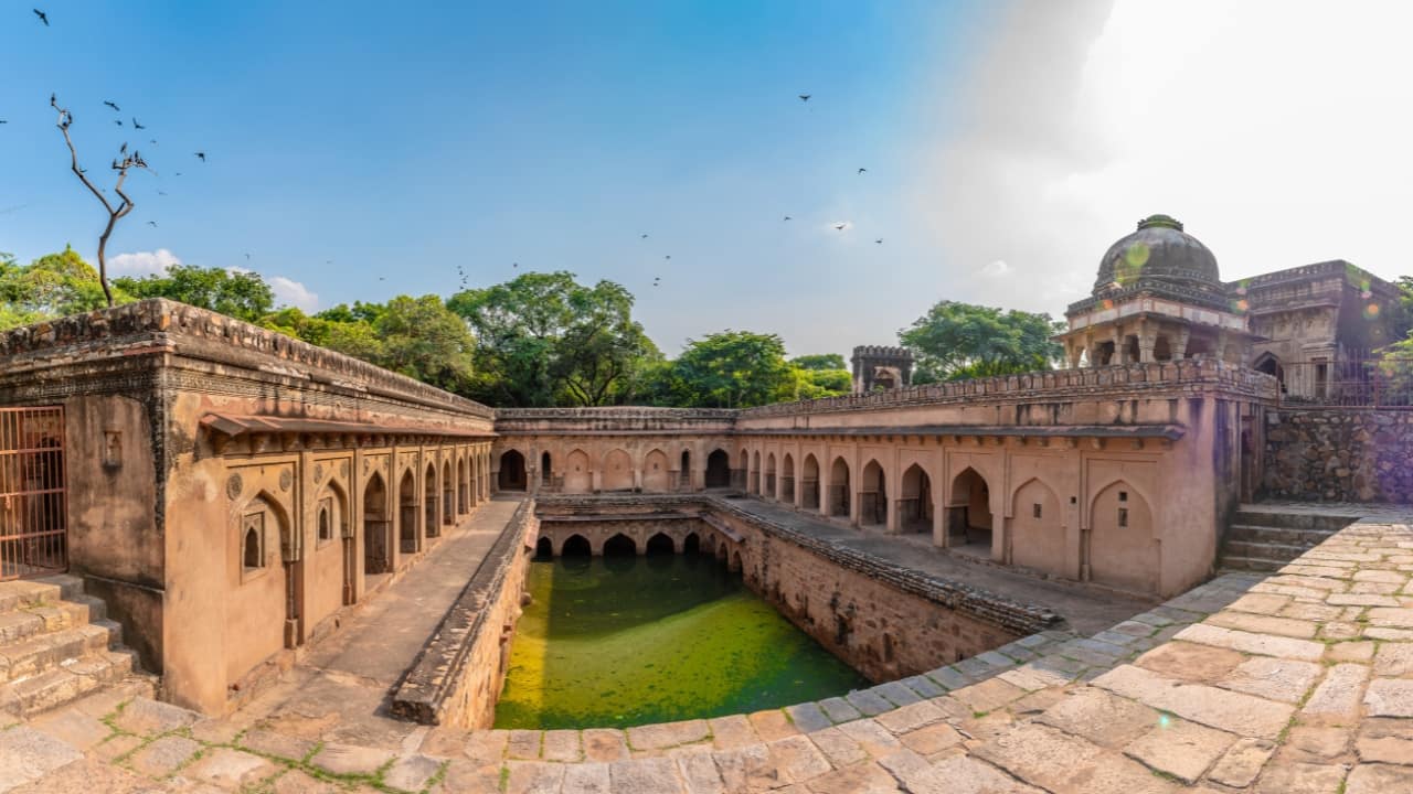 8. Rajon Ki Baoli, Delhi – A Stepwell Lost in Time Where: Mehrauli, Delhi Why Go: Tucked inside the Mehrauli Archaeological Park, this 16th-century stepwell is often overlooked by tourists. With its arched corridors and quiet atmosphere, it feels like a forgotten relic waiting to be rediscovered. How to Get There: Nearest metro is Qutub Minar Station, followed by a short walk. (Image: canva)