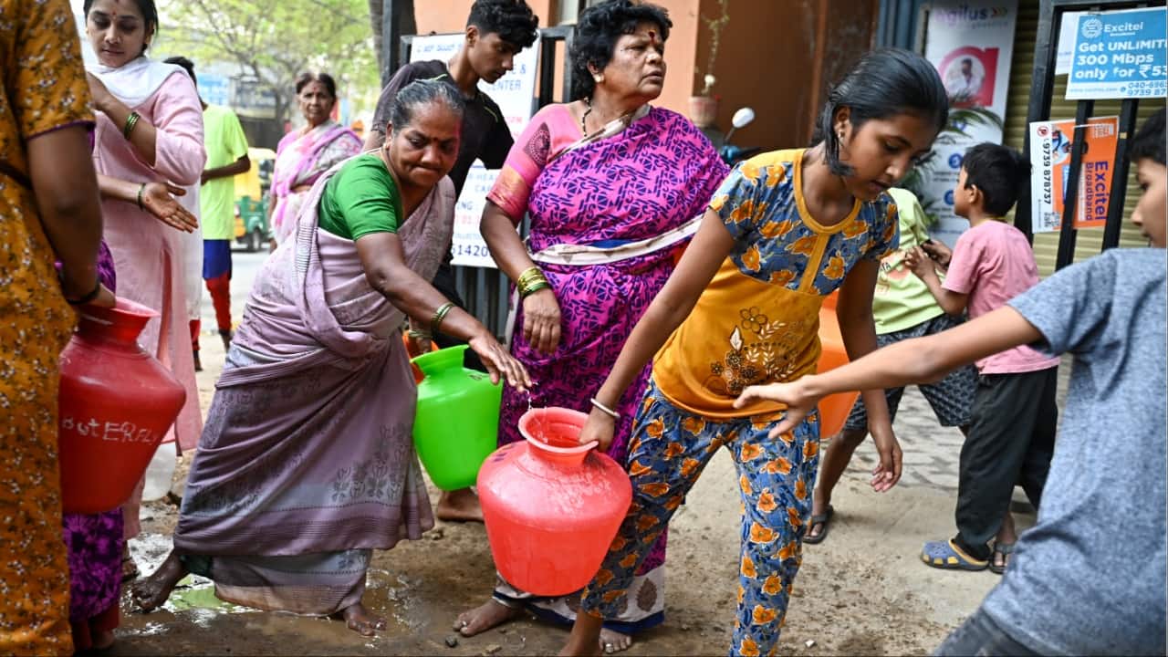 Residents collect free water from a municipal tanker amidst the ongoing water crisis in Bengaluru last year. (Image credit: AFP)