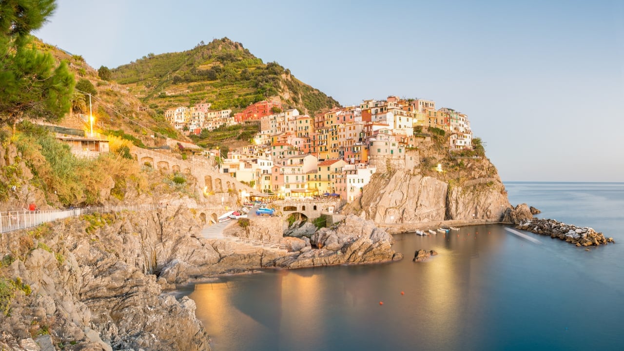 3. Cinque Terre National Park, Italy – Where the Mountains Meet the Sea If you’ve ever seen pictures of Italy’s colorful cliffside villages, chances are they were taken in Cinque Terre. This stunning coastal park offers dreamy hiking trails with vineyard-covered hills on one side and the sparkling Mediterranean on the other. After a scenic trek, reward yourself with fresh seafood and a glass of local wine while watching the sunset—it doesn’t get better than this. (Image: Canva)