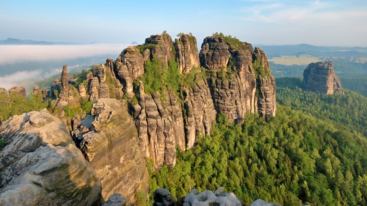 7. Saxon Switzerland National Park, Germany – A Fairytale Landscape Don’t be fooled by the name—this park isn’t in Switzerland! Located in eastern Germany, it’s a wonderland of towering sandstone cliffs, hidden caves, and medieval castles perched dramatically on rocky outcrops. The highlight? The Bastei Bridge, where you can stand high above the Elbe River and take in views so beautiful they seem unreal. (Image: Canva)