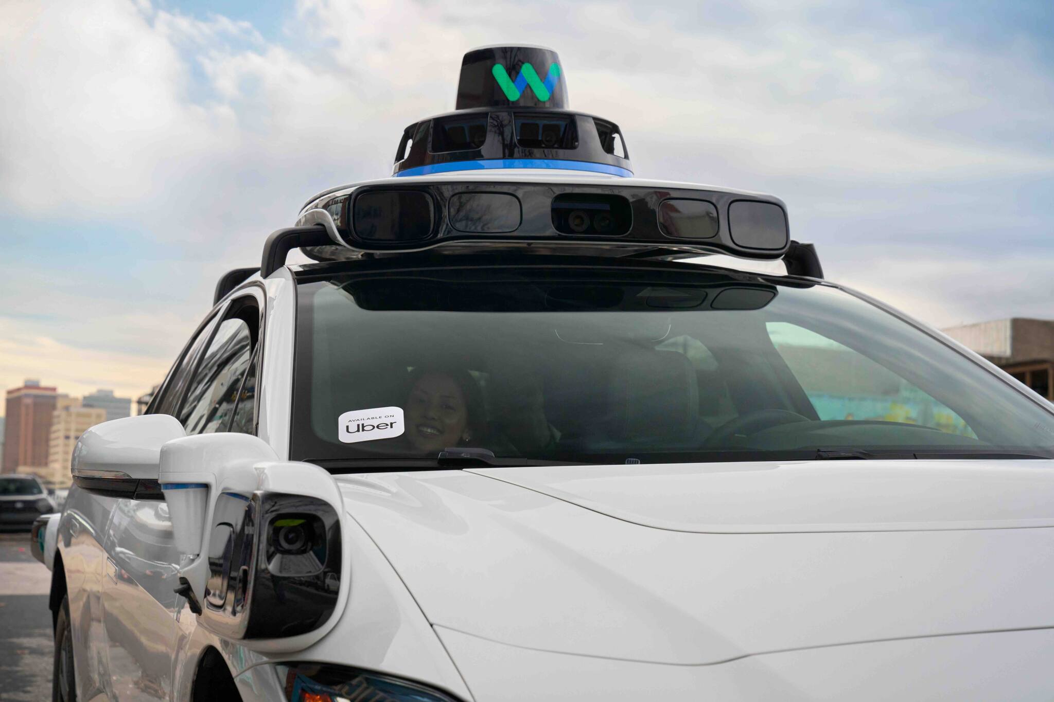 An Uber customer takes a ride in a driverless Waymo car in Austin, Texas
