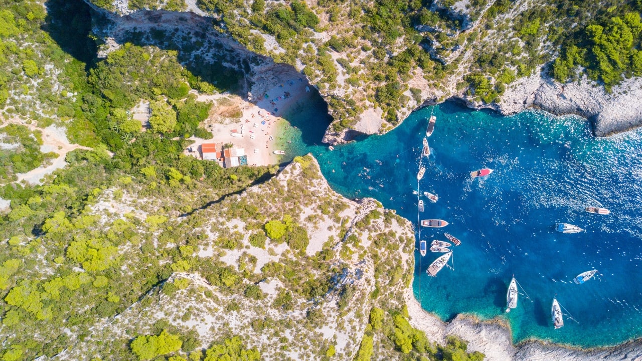 9. Stiniva Cove, Croatia – Porco Rosso’s Hidden Escape Tucked away on Vis Island, Stiniva Cove is one of Croatia’s best-kept secrets. Its dramatic cliffs, hidden entrance, and crystal-clear waters make it the perfect real-life version of Porco Rosso’s secluded hideout. Whether you’re swimming, sunbathing, or just admiring the view, this cove feels like a secret world waiting to be discovered. (Image: Canva)