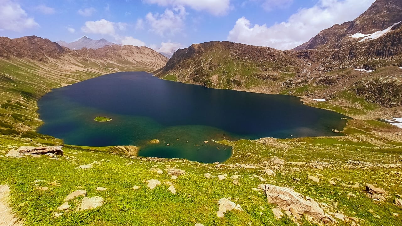 1. Tarsar Lake Hidden deep in the Aru Valley, Tarsar stuns with its shifting shades of turquoise, teal, and green. Surrounded by grassy slopes and scattered boulders, it's a trekker’s paradise. Camp by its shores and watch the sunrise turn the lake into liquid gold, reflecting the peaks in a dance of light. (Image: Canva)