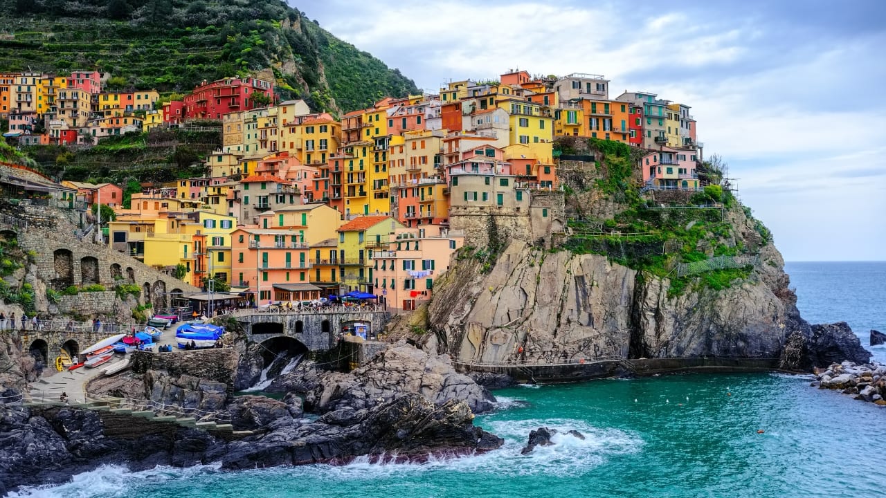 9. Cinque Terre, Italy The villages of Cinque Terre are famous for their colorful houses perched on cliffs that look like they were painted by the gods. These five coastal gems in Italy’s Liguria region glow in shades of red, yellow, and orange, contrasting with the sparkling Mediterranean Sea below. Hiking between the villages offers incredible views, and each colorful corner holds a piece of Italian charm. (Image: Canva)
