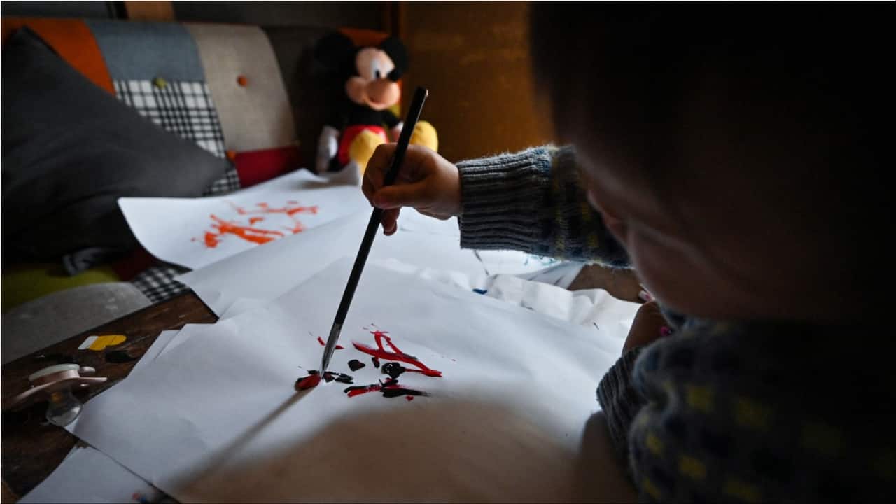 Thumbelina uses a brush to paint in the family's home in Tokyo. (Image credit: AFP)