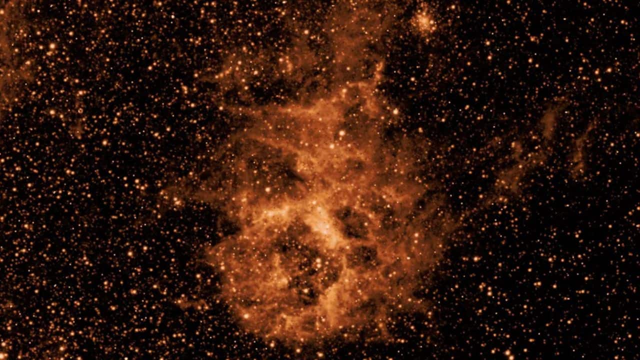 NASA's SPHEREx mission is observing the entire sky in 102 infrared colors, or wavelengths of light not visible to the human eye. This image shows a section of sky in one wavelength (3.29 microns), revealing a cloud of dust made of a molecule similar to soot or smoke. (Image: NASA/JPL-Caltech