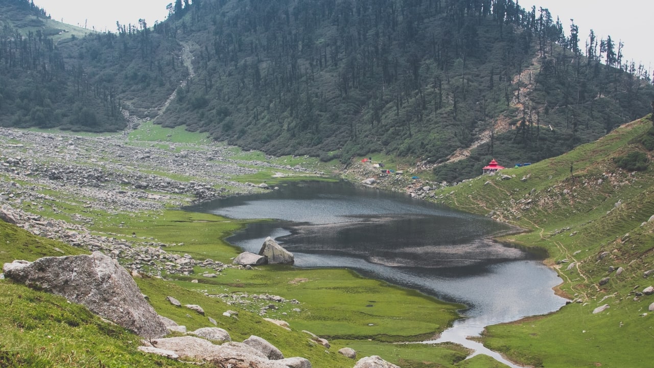 7. Kareri Lake, Himachal Pradesh – Forest Trails to a Crystal Lake Just a few hours from Dharamshala, Kareri is one of Himachal’s best-kept secrets. This high-altitude lake is fed by melting snow, and the trail passes pine forests, gurgling streams, and charming mountain villages. (Image: Canva) Best time to visit: May–June, September–October Trek difficulty: Moderate