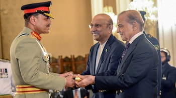 Pakistan's Prime Minister Shehbaz Sharif (R) and President Asif Ali Zardari (C) jointly conferring the Baton of Field Marshal on Chief of Army Staff General Syed Asim Munir during a ceremony at the country's President House. 