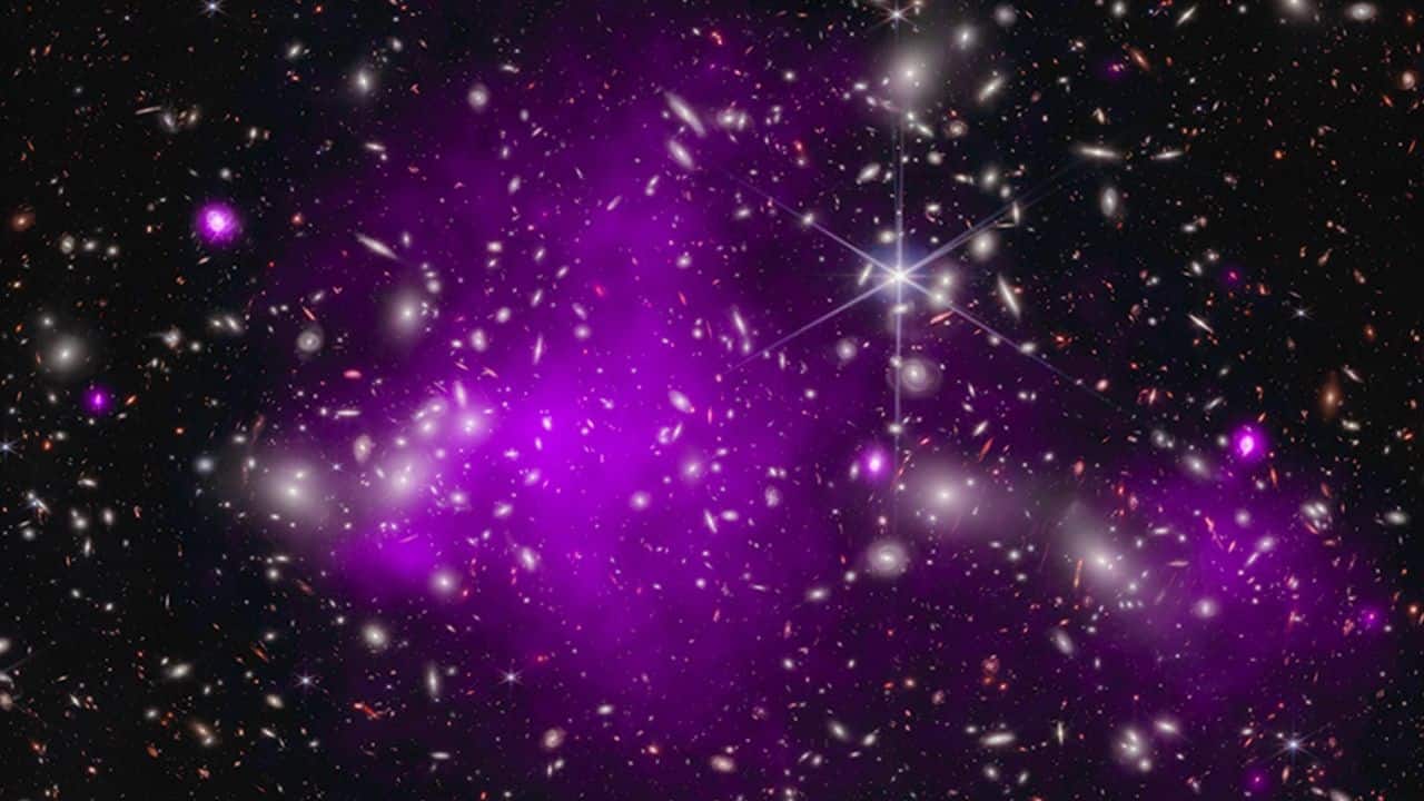 Record-breaking Black Hole in Galaxy UHZ1: This image contains the most distant black hole ever detected in X-rays, a result that may explain how some of the first supermassive black holes in the universe formed. This discovery was made using X-rays from NASA’s Chandra X-ray Observatory (purple) and infrared data from NASA’s James Webb Space Telescope (red, green, and blue). (Image: NASA)