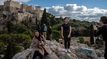 People visit the Aeropagus hill as the Acropolis is seen in the background in Athens on December 3, 2024. (File photo: AFP)