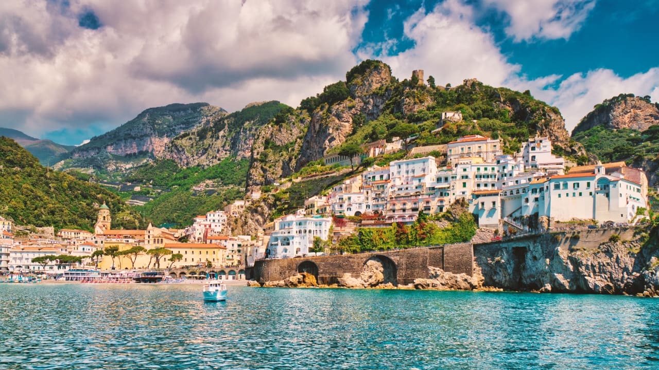 1. Amalfi Coast, Italy – Where Mountains Meet the Mediterranean With lemon groves clinging to cliffs and pastel towns tumbling to the sea, the Amalfi Coast is summer seduction in its purest form. Drive the winding coast, sip limoncello, and dive into turquoise coves. (Image: Canva)