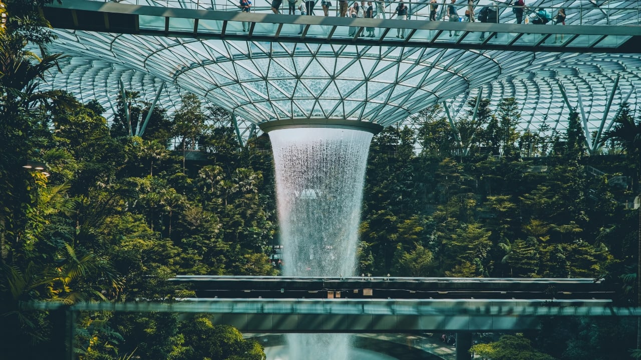 2. Singapore Changi Airport, Singapore Changi isn’t just an airport; it’s a destination. From rainforest gardens and the tallest indoor slide in the world to immersive digital zones and movie theatres, this airport transforms transit into adventure. Parents will appreciate the pristine nursing rooms and wide stroller-friendly walkways. (Image: Canva)