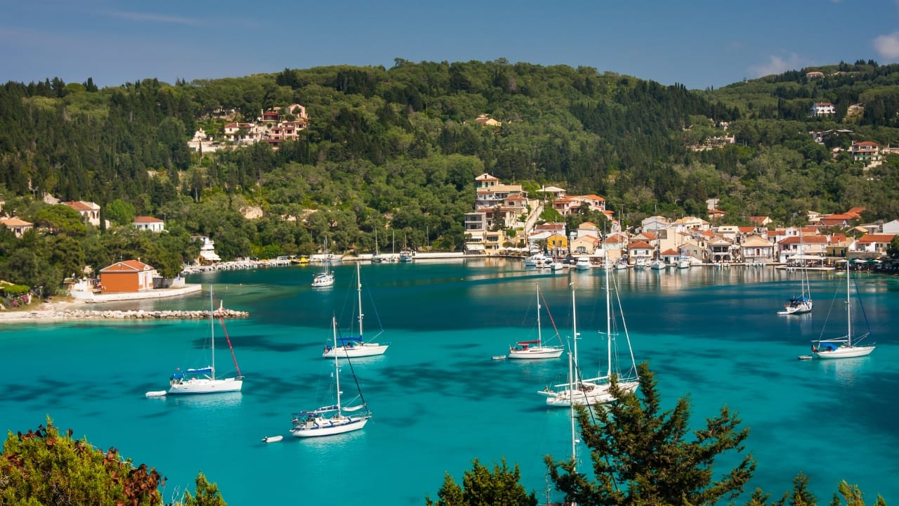 5. Paxi – An Island of Olive Trees and Sea Caves Paxi, barely more than a dot below Corfu, is a place where olive groves spill toward the sea and the water is impossibly, unapologetically blue. There is no airport, no rush. Just a ferry, a promise of quiet, and the scent of thyme. Antipaxos, its smaller sibling, offers beaches that resemble dreams half-remembered. (Image: Canva)
