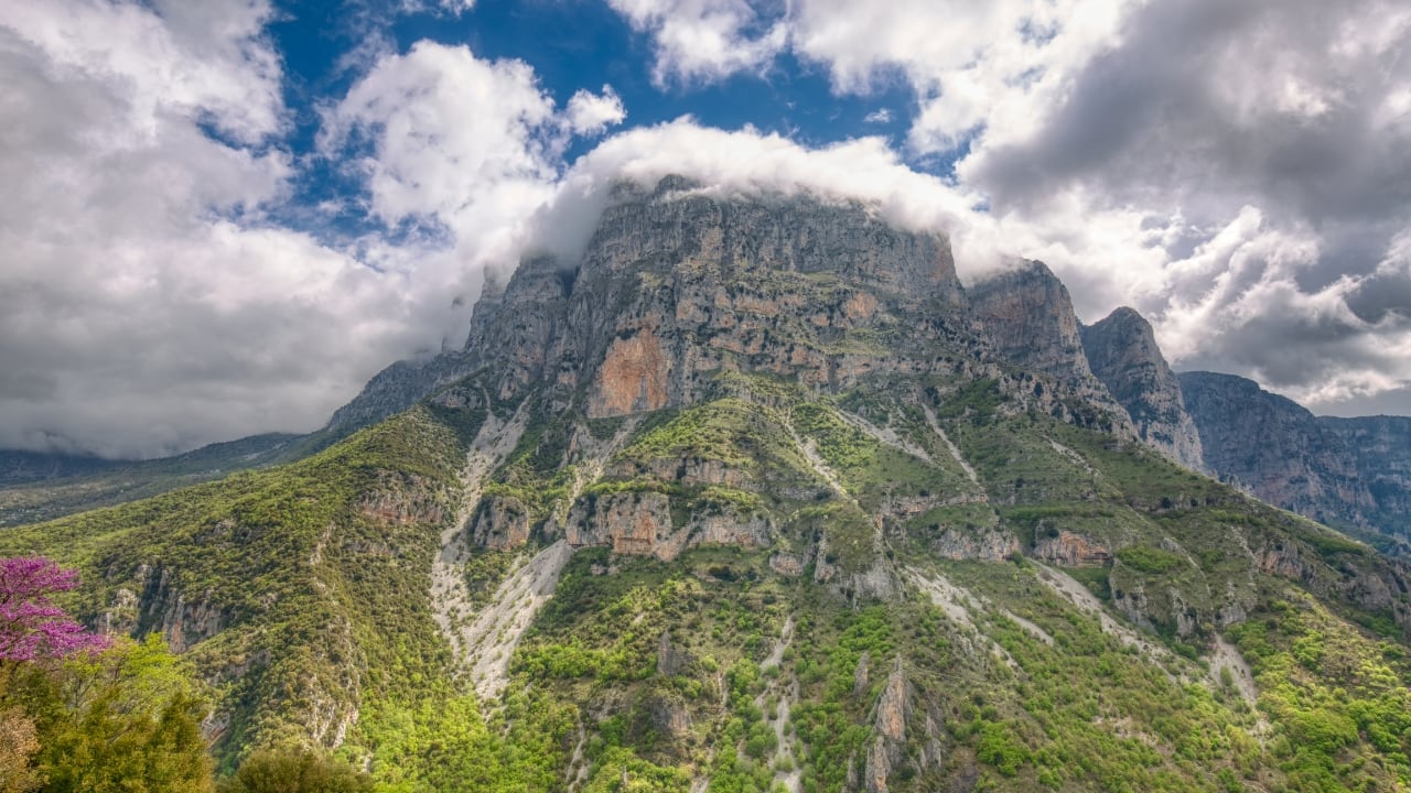 8. Zagori – The Silence of Stone In Epirus, far from the glitter of the islands, Zagori stretches like a forgotten tapestry. Forty-six villages—Zagorochoria—are joined by ancient stone bridges that arch like the backs of sleeping animals. The Vikos Gorge splits the earth here with the quiet violence of geologic time. And in the silence of this mountain world, one begins to hear their own thoughts again. (Image: Canva)