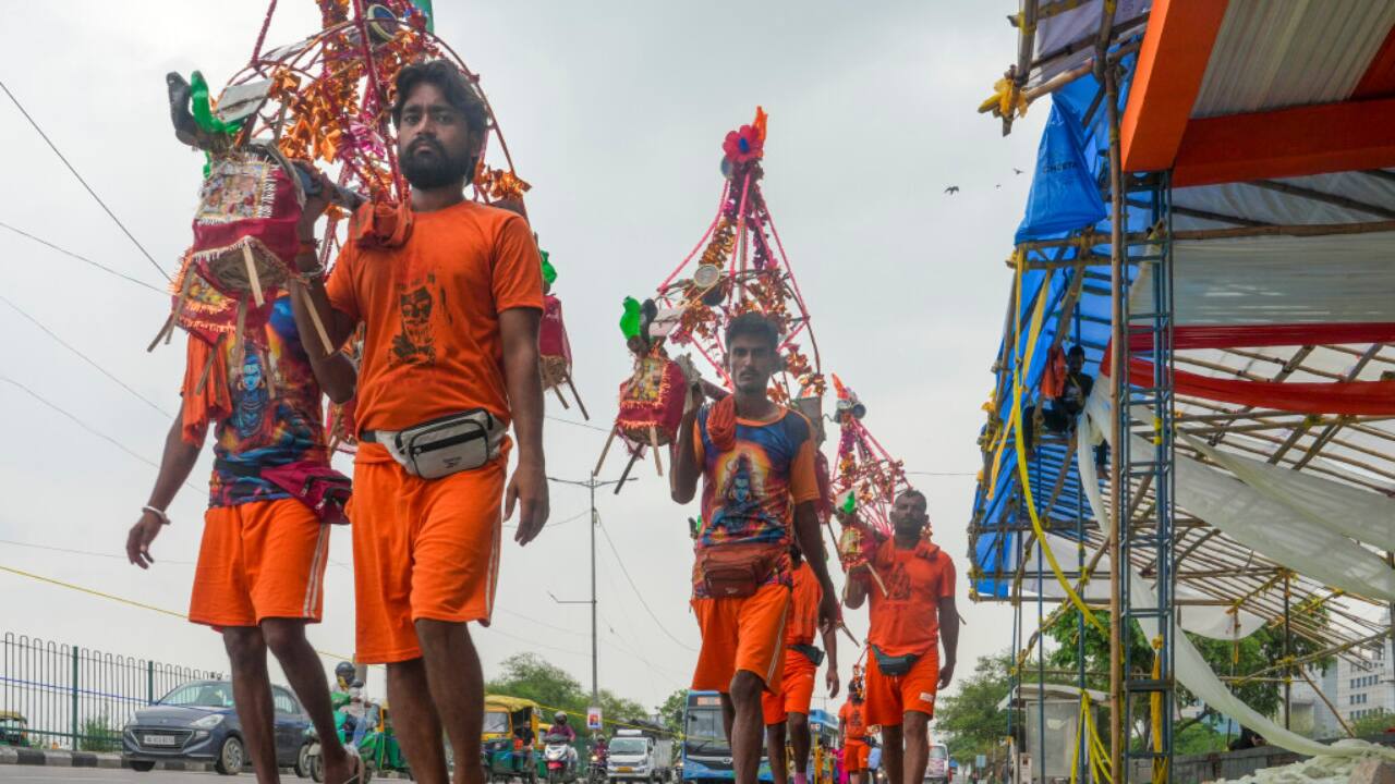 3. New Delhi, July 13: Kanwariyas walk on city roads in Delhi as part of their journey during the Kanwar Yatra of Shravan month. (PTI/Manvender Vashist Lav)