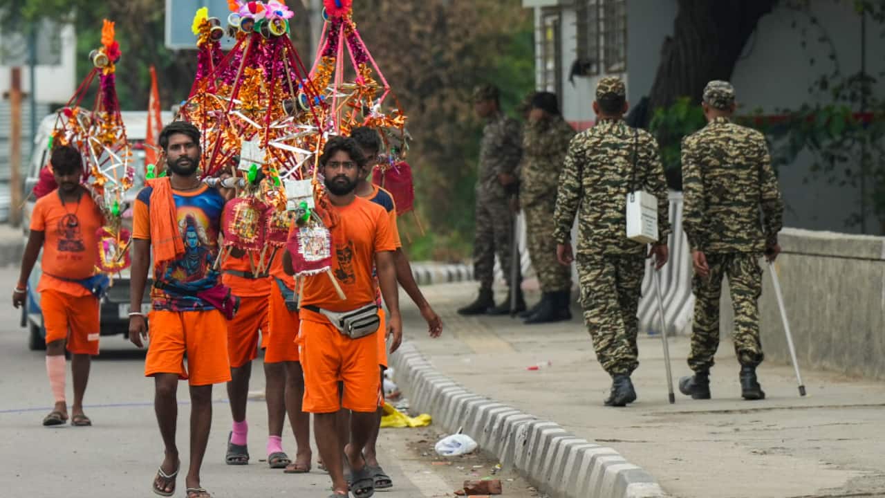 6. New Delhi, July 13: Kanwariyas chant Lord Shiva’s name while walking through Delhi streets during the Shravan Yatra. (PTI/Manvender Vashist Lav)