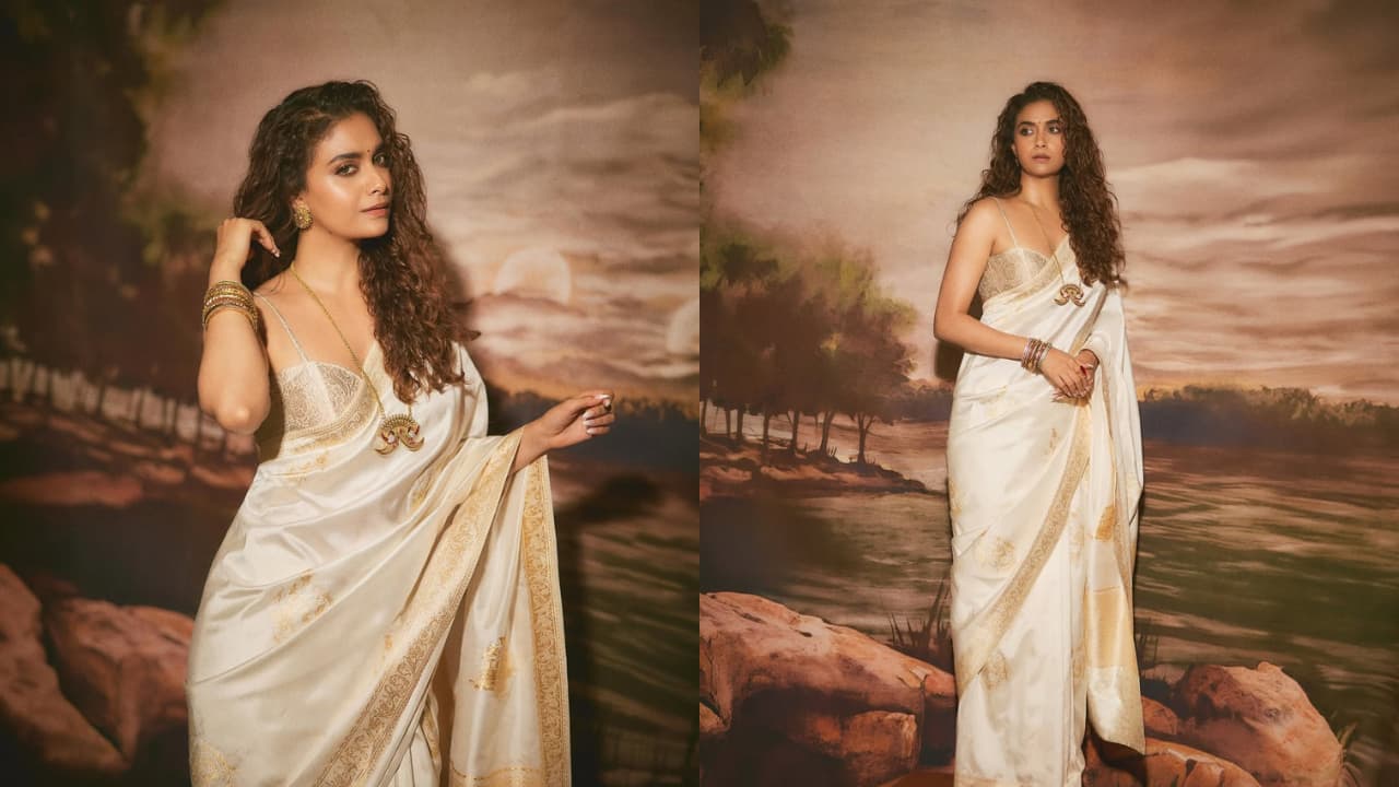 Keerthy Suresh The actress, who’s had quite a busy year professionally, stuns in a handwoven ivory Banarasi saree. However, what steals the spotlight is her blouse design featuring noodle straps and a plunging neckline. It adds a modern touch to the traditional drape, enhanced by her long neckpiece.