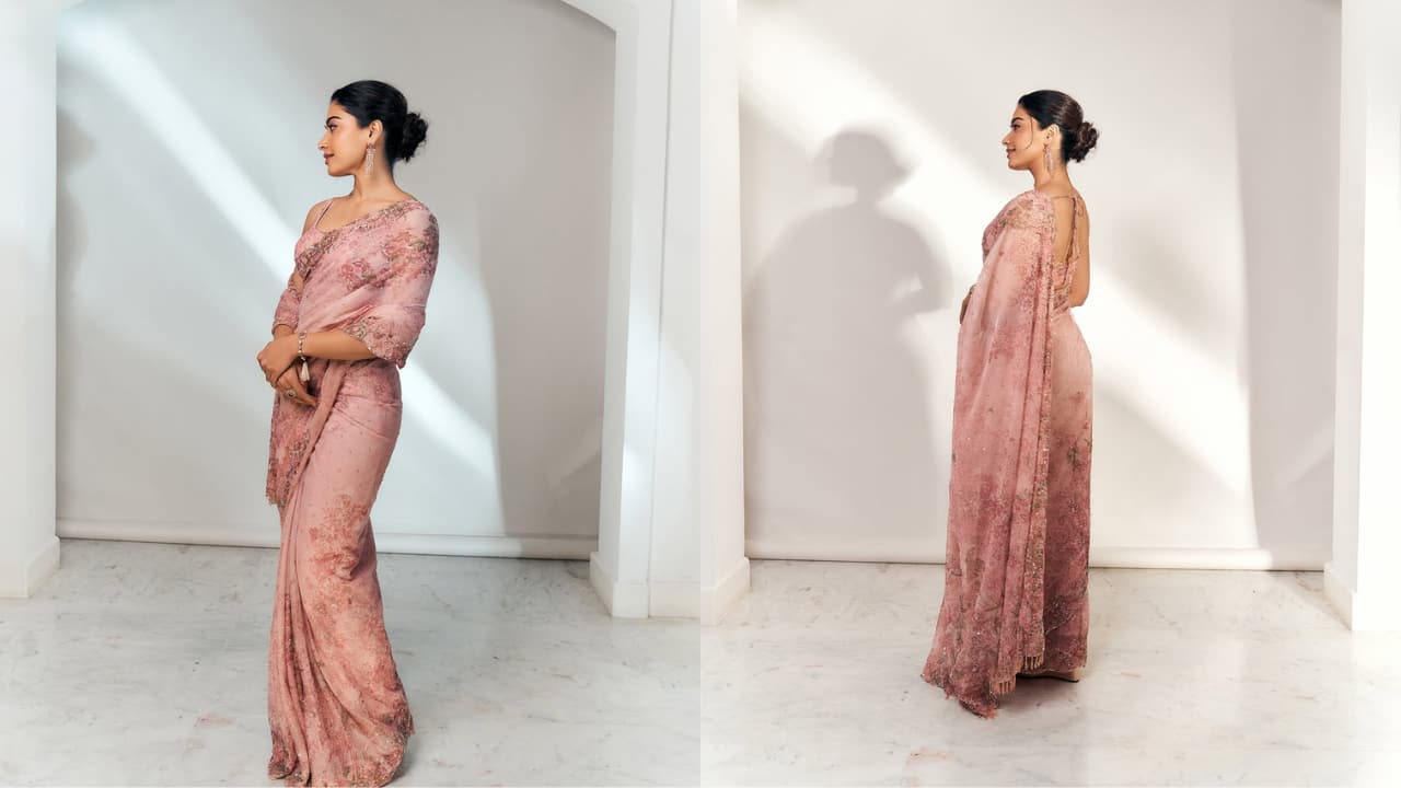 Rashmika Mandanna Rashmika is a vision in a fresh floral blush-pink saree with delicate embroidery. Her blouse matches the drape beautifully, and the dori at the back adds a vintage touch. Her refreshing look is accessorised with pretty pink jewellery, while her hair bun shows off the back design.