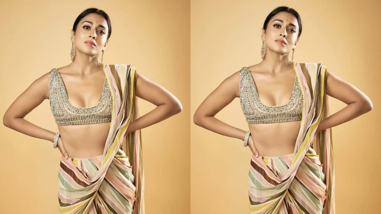 Shriya Saran The actress shines in a vibrant pre-draped saree, elegantly paired with a sultry crop blouse featuring ornate Swarovski crystal embroidery. The blouse elevates the look of the drape, which is tied in a modern fashion. Needless to say, Shriya looks mesmerising in this one.