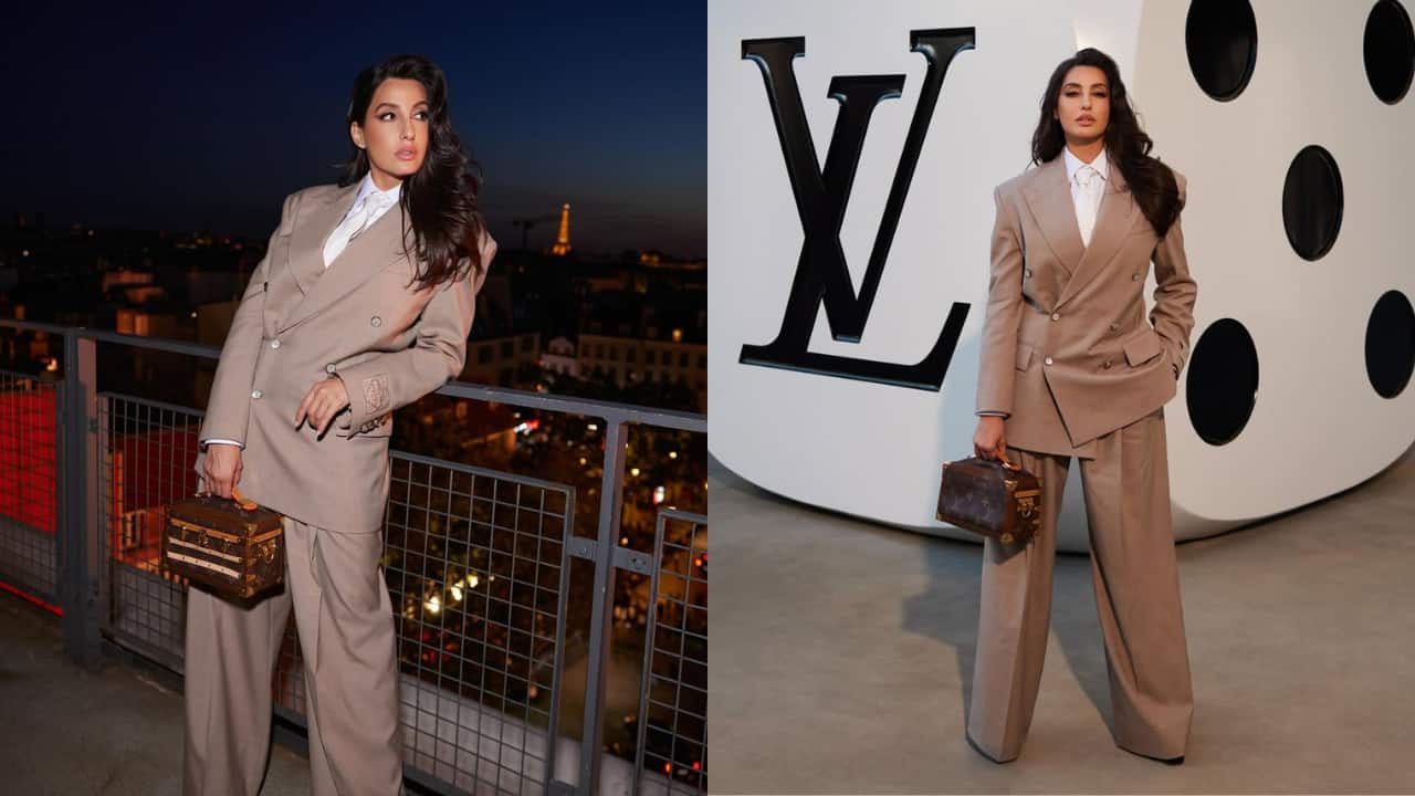 Nora Fatehi Nora Fatehi attended Louis Vuitton’s Spring/Summer 2026 Menswear show at Paris Fashion Week, looking chic in an oversized taupe suit. She carried a classic LV monogram mini trunk and sported chunky black wedges to complete the look.