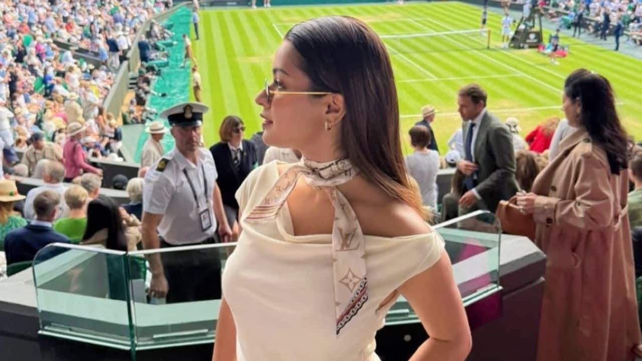 Adding a sophisticated touch, she accessorized with a patterned neck scarf, sleek sunglasses, and a tan mini handbag, effortlessly blending elegance with edge.