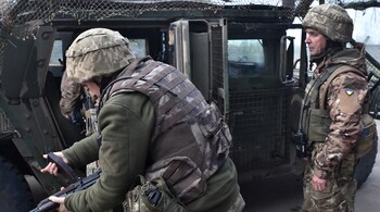 In this handout photograph taken and released by the press service of the 65th Mechanized Brigade of Ukrainian Armed Forces on May 5, 2025, Ukrainian servicemen prepare to get into a military vehicle at an undisclosed location on the front line in the Zaporizhzhia region, amid the Russian invasion of Ukraine. (Photo by Andriy ANDRIYENKO / 65th Mechanized Brigade of Ukrainian Armed Forces / AFP)