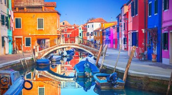 Burano, crowned the world’s most colourful city, dazzles with its vividly painted homes lining serene Venetian canals. (Image: Canva)