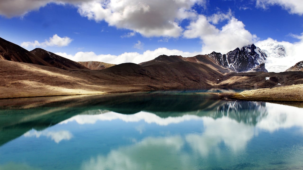 3. Gurudongmar Lake, Sikkim At over 17,000 feet above sea level, Gurudongmar Lake presents an austere and otherworldly beauty. Its turquoise waters remain partially frozen for much of the year, framed by snow-covered peaks that give it a stark, pristine elegance. The surrounding silence completes a setting that feels almost celestial. (Image: Canva)