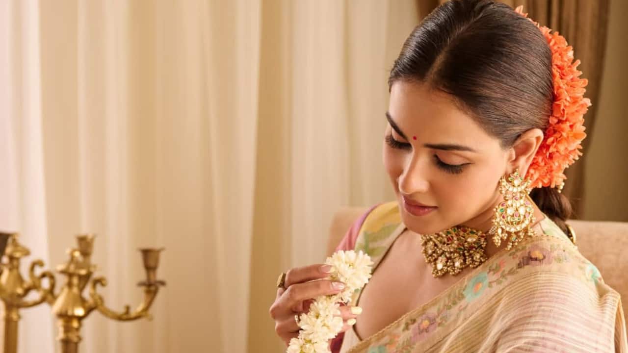 Floral grace Genelia Deshmukh looks radiant in a beige saree with floral patterns, sitting gracefully on an intricate carpet. Surrounded by soft lighting and elegant decor, she exudes traditional charm.  Floral grace Genelia Deshmukh looks radiant in a beige saree with floral patterns, sitting gracefully on an intricate carpet. Surrounded by soft lighting and elegant decor, she exudes traditional charm.