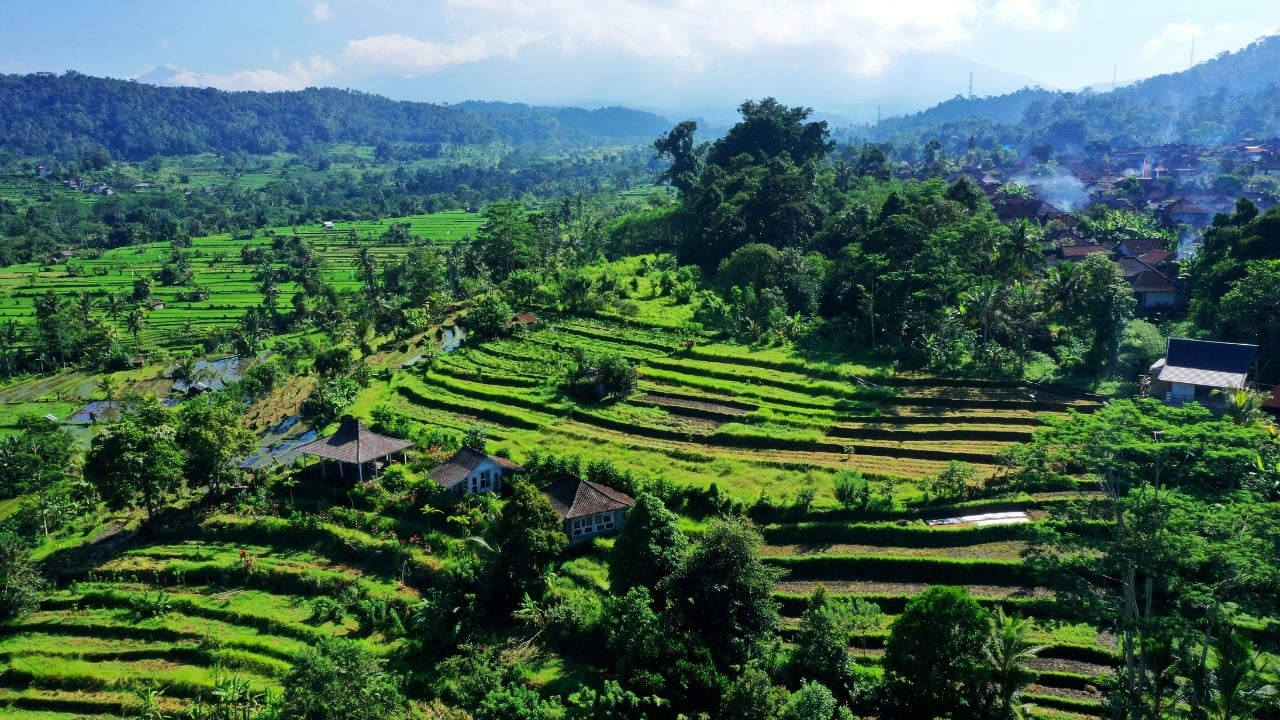 1. Sidemen Valley: The Soul of Rural Bali Located in East Bali, Sidemen is a lush valley that feels like a time capsule. The region is framed by Mt. Agung, Bali’s sacred volcano, and layered with stunning rice terraces, bamboo forests, and sleepy villages. Hike through the fields, visit traditional weaving centers, or simply relax in a bamboo hut overlooking a river. It’s a favorite among yogis, writers, and slow travelers looking to escape the buzz of Ubud. Why go: Serene landscapes, fewer tourists, great base for cultural immersion and eco-friendly stays. (Image: Canva)