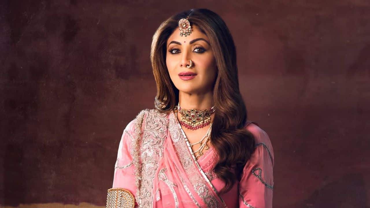 2. Elaborate Traditional Jewelry Her look is significantly enhanced by a complete set of traditional Indian jewelry. This includes a prominent maang tikka on her forehead, a delicate nath (nose ring), a multi-layered and ornate necklace, and numerous bangles and kadas on her wrists. An armlet (bajubandh) is also visible, all contributing to a majestic and culturally rich aesthetic. 2. Elaborate Traditional Jewelry Her look is significantly enhanced by a complete set of traditional Indian jewelry. This includes a prominent maang tikka on her forehead, a delicate nath (nose ring), a multi-layered and ornate necklace, and numerous bangles and kadas on her wrists. An armlet (bajubandh) is also visible, all contributing to a majestic and culturally rich aesthetic.